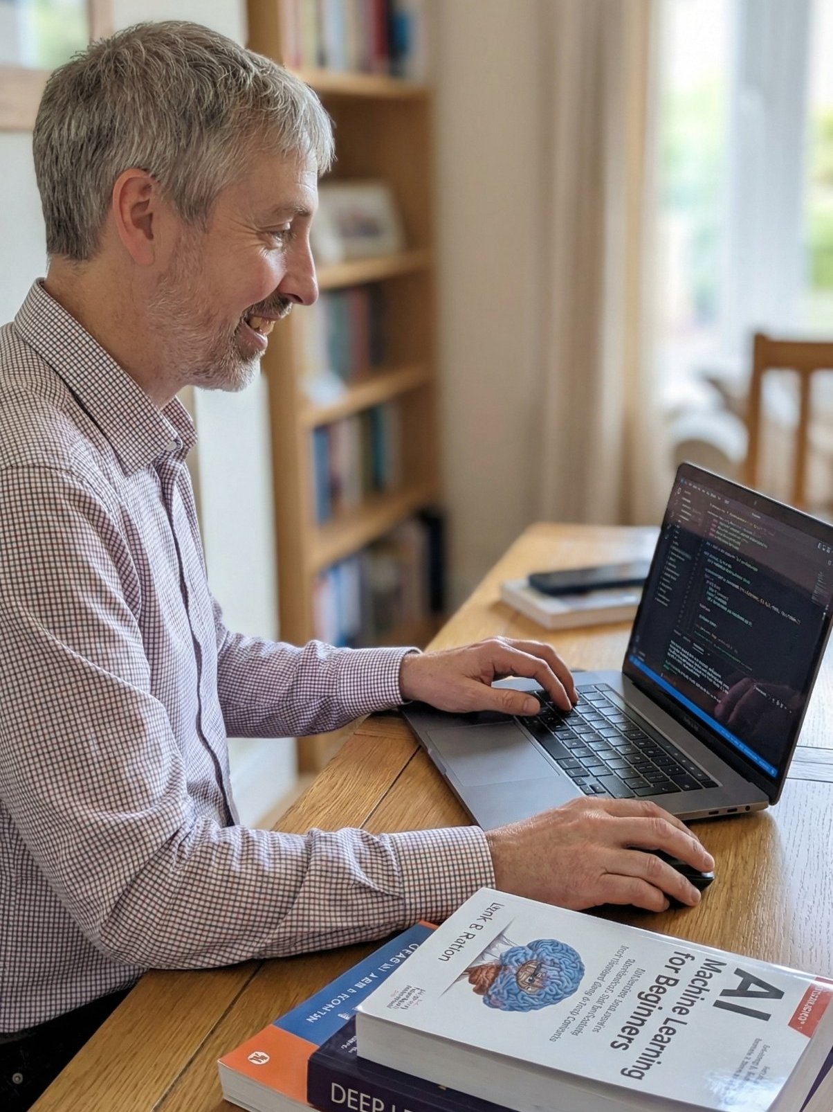 Rufus Curnow working at his desk with AI and machine learning books